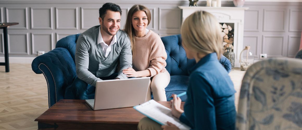 Couple sitting on couch with realtor.