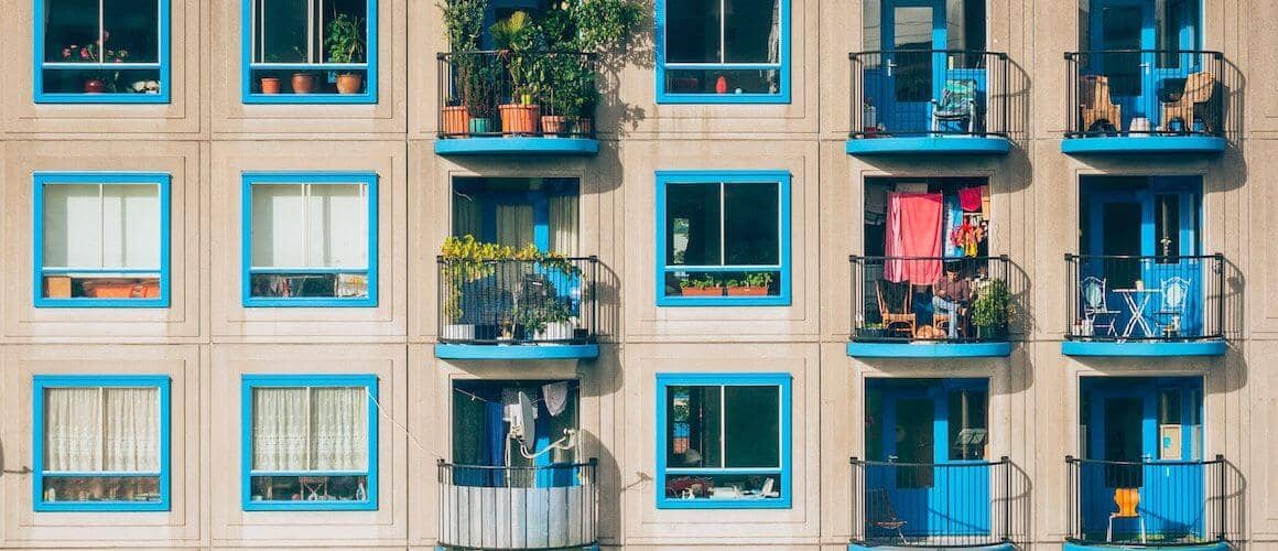 Apartment wall with lines of windows with blue colored trims.