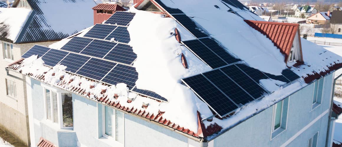 Solar panels on roof with snow on it.
