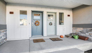 Duplex front doors with ornamental wreath decorations.