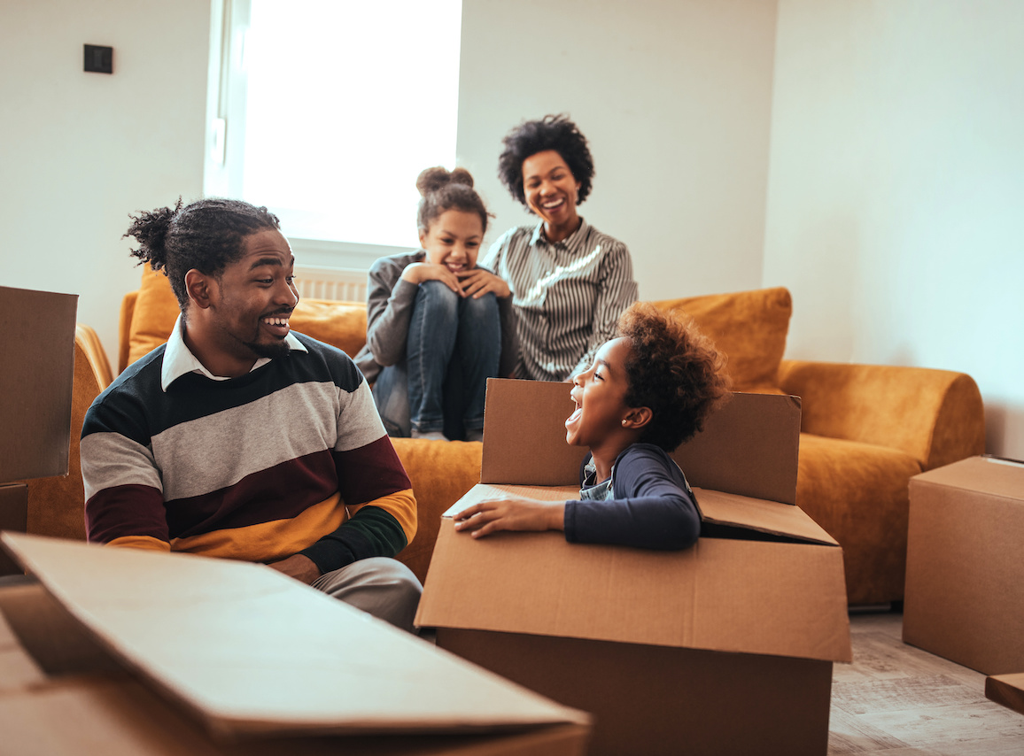 Shot of a happy family having fun in their home on moving day with moving boxes.